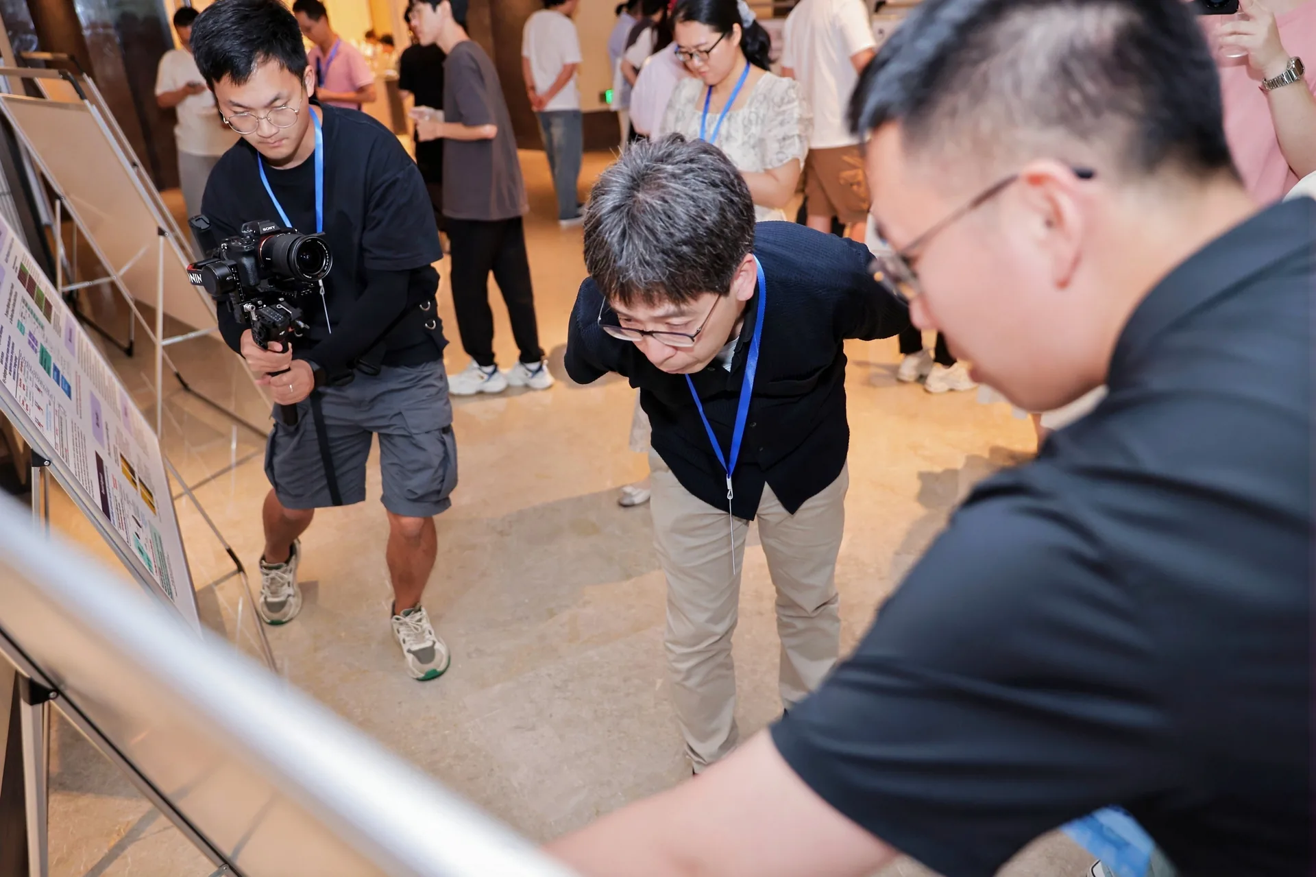 Hisashi Ohtsuki talking with a poster presenter at EGAI 2026